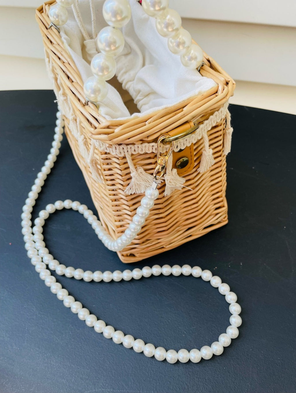 Woven straw basket purse with fringe accent and pearl handles