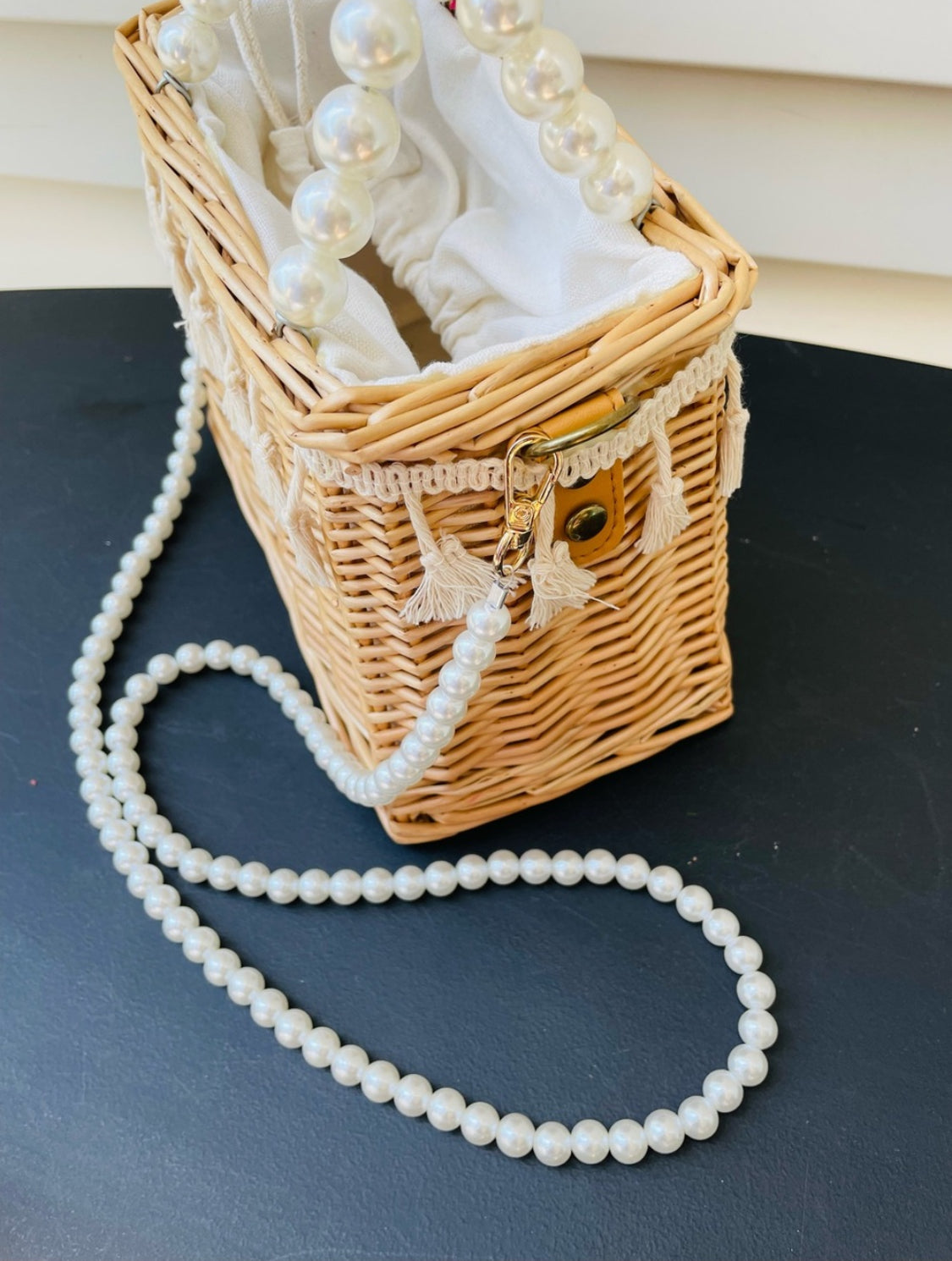 Woven straw basket purse with fringe accent and pearl handles